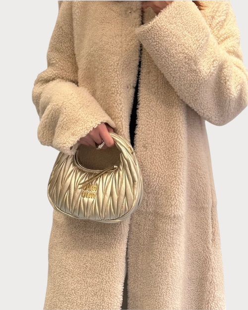 LONDONKELLY presents the MIU MIU Wander Matelasse Nappa Leather Hobo Mini-Bag in metallic gold. This small, quilted leather bag features a curved silhouette and the iconic Miu Miu logo.