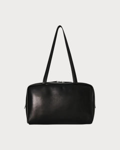 LONDONKELLY The Row Astra black lambskin leather bowling bag with dual zipper closure and elongated handles.